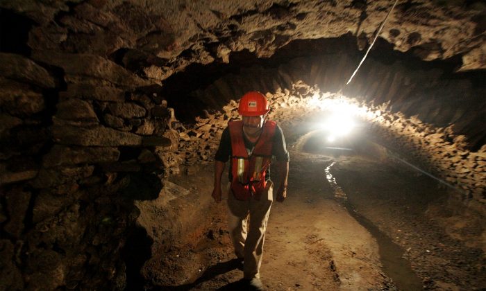 A worker walks through one of the recently discovered ancient tunnels underneath the city of Puebla, Mexico, Thursday, Sept. 3, 2015. (AP Photo/Joel Merino)