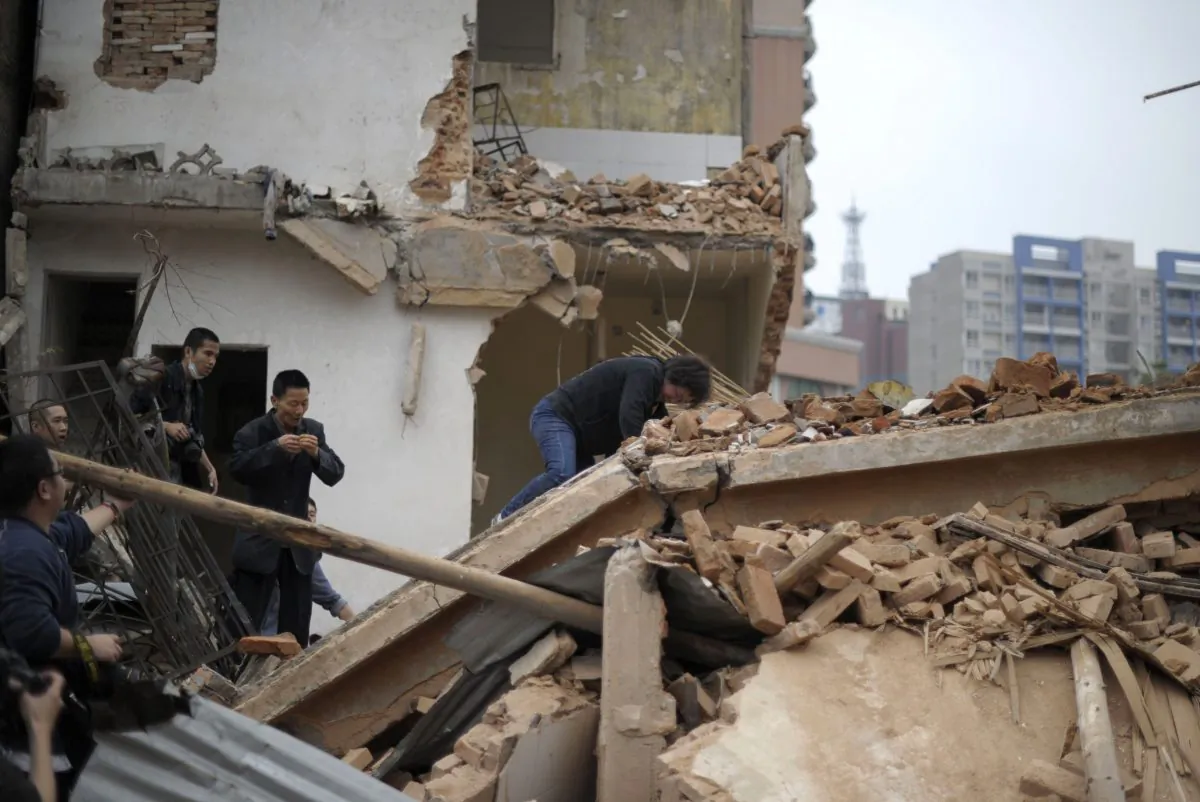 Huang Sufang (C) reacts after attempting to protect her home as workers move in for demolition orders in Yangji village, Guangzhou, south China's Guangdong province on March 21, 2012. (STR/AFP/Getty Images)