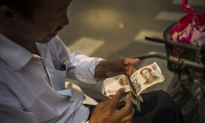 A man checks Chinese yuan bills in Beijing on July 28, 2015. (Fred Dufour/AFP/Getty Images)