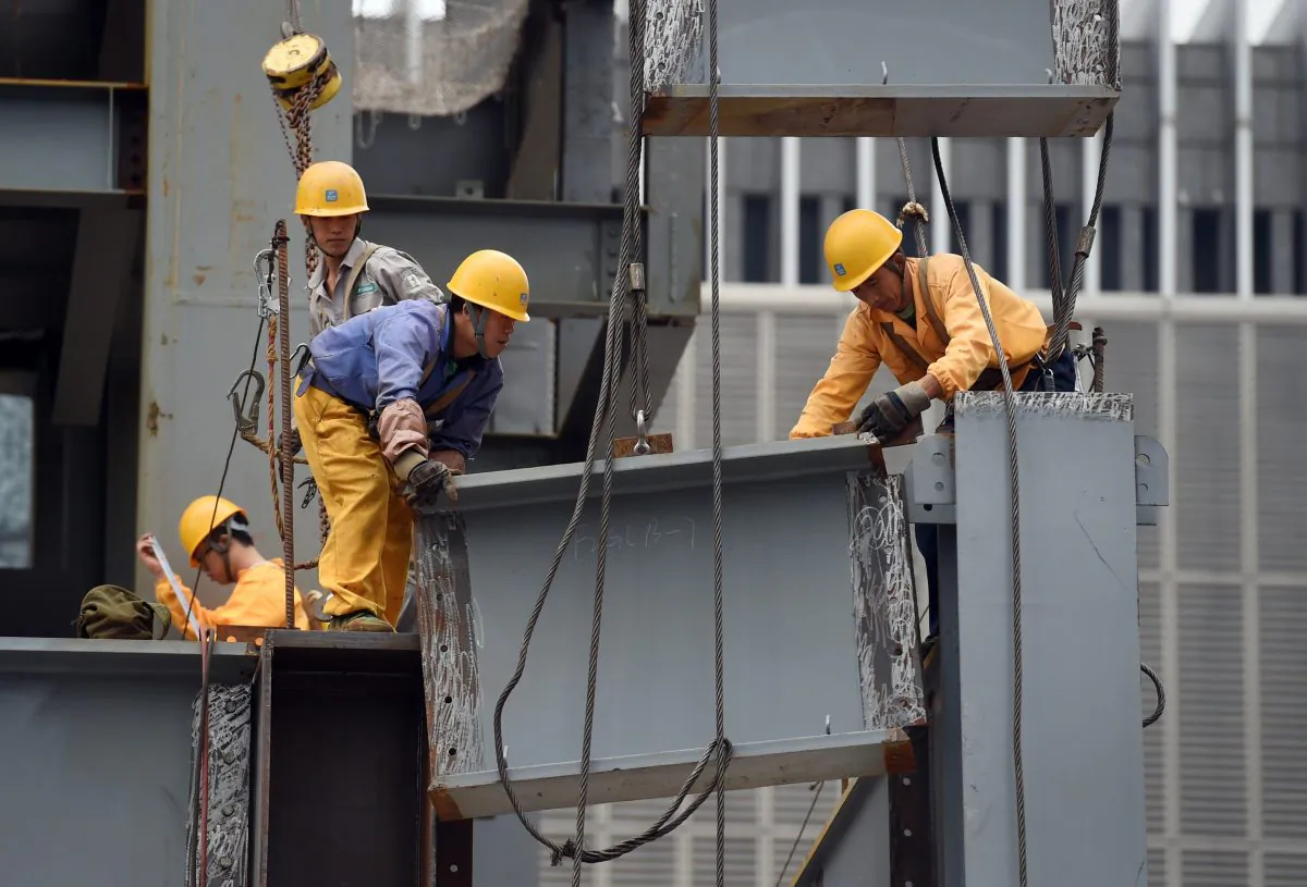 Workers install a section of a steel beam on a construction site in Beijing on Sept. 9, 2015. (Greg Baker/AFP/Getty Images)