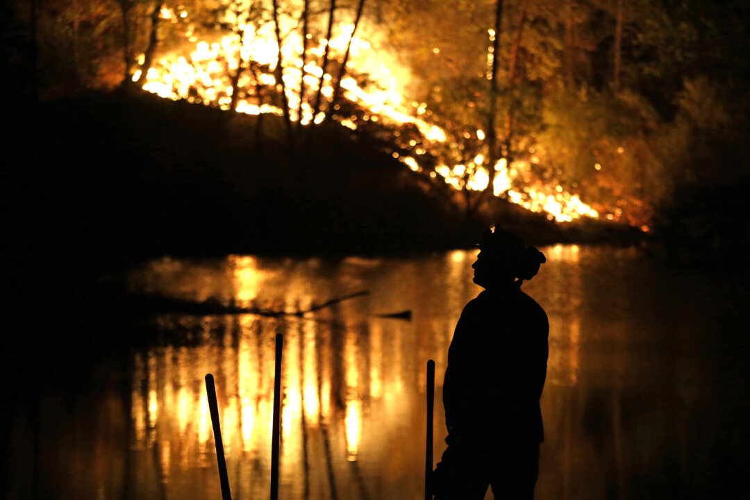 A firefighter stands near a wildfire in Middletown, Calif., on Sept. 13, 2015. (AP Photo/Elaine Thompson)