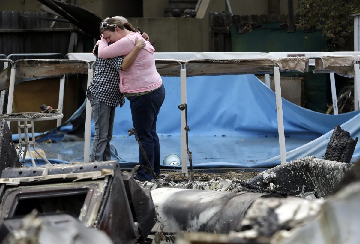 Deanna Hingst, right, embraces her mother Shirley Leuzinger as they stand at the family's destroyed home Monday, Sept. 14, 2015, in Middletown, Calif. (AP Photo/Elaine Thompson)