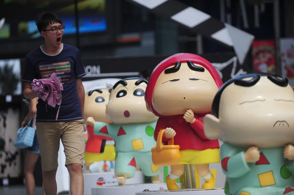 A man walking by sculptures during a Crayon Shin-chan exhibition in Shenyang, northeast China's Liaoning province on This photo taken on July 11. (STR/AFP/Getty Images)
