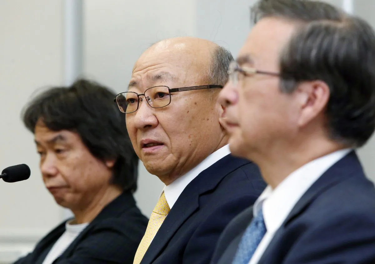 Tatsumi Kimishima (C), newly appointed president of Japanese videogame giant Nintendo speaks to reporters at the Osaka Stock Exchange on Sept. 14, 2015, while Nintendo's famous game creator Shigeru Miyamoto (L) looks on. (Jiji Press/AFP/Getty Images)