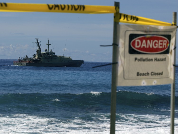 140158600 Australian Navy boat cruises by a closed beach