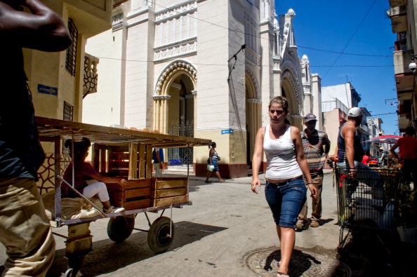 Cubans walk next to Our Lady of Charity Epoch Times Photo