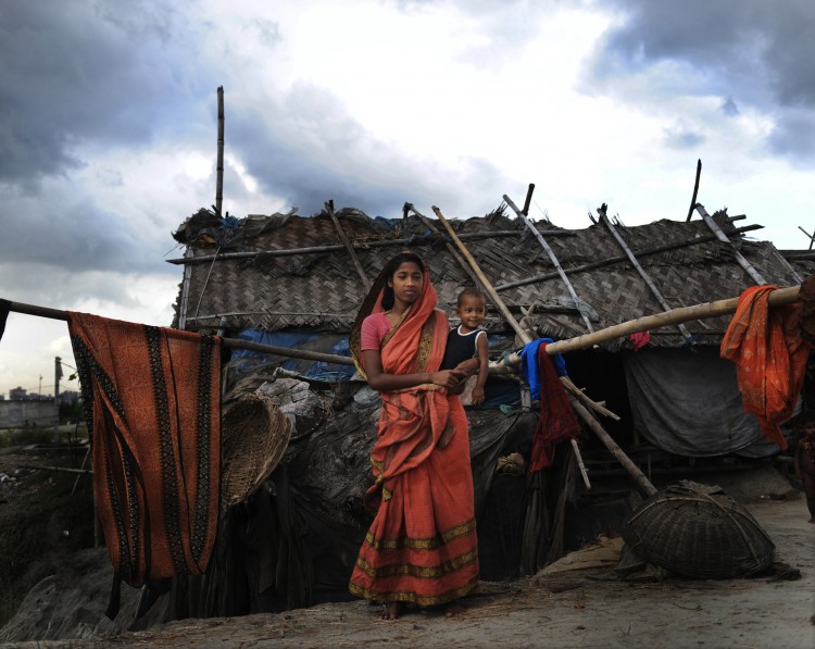 Suriya Begum, a slum dweller in the Bangladeshi capital Dhaka, holds her baby (file photo). A new report states that the least developed countries suffered a 7 percent decline in GDP due to climate change in 2010. (Munir Uz Zaman/AFP/Getty Images)
