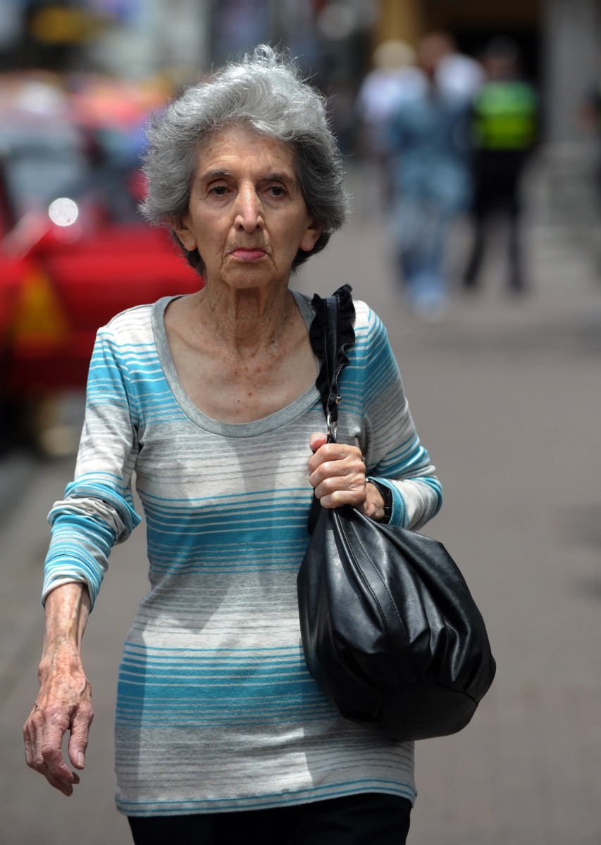 An elderly woman walks in San Jose An elderly woman walks in San Jose