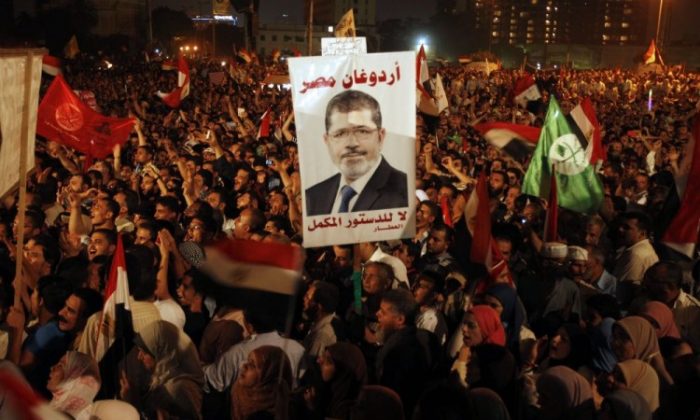 Thousands of Egyptian supporters of Muslim Brotherhood presidential candidate Mohammed Mursi (portrait) gather in Cairo's Tahrir Square on June 19, 2012. (Patrick Baz/AFP/GettyImages)
