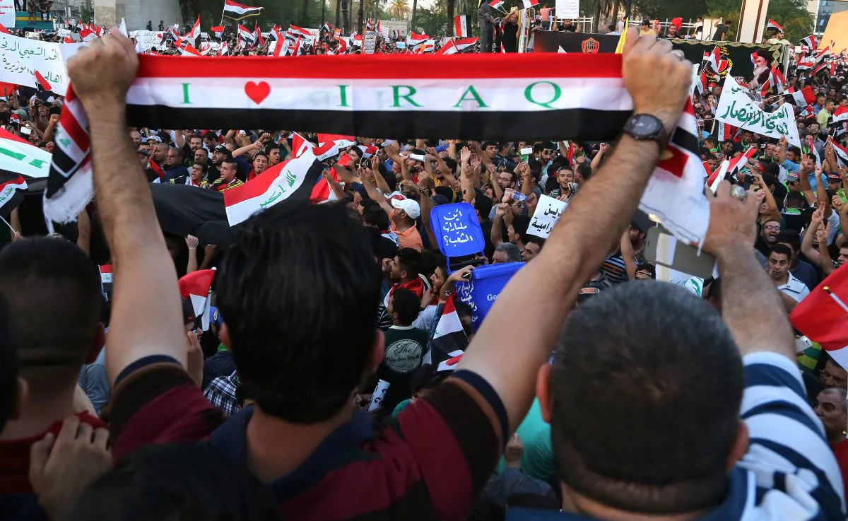 Demonstrators chant in support of Iraqi Prime Minister Haider al-Abadi as they wave national flags during a demonstration in Tahrir Square in Baghdad, Iraq, on Aug. 14, 2015. (Karim Kadim/AP)
