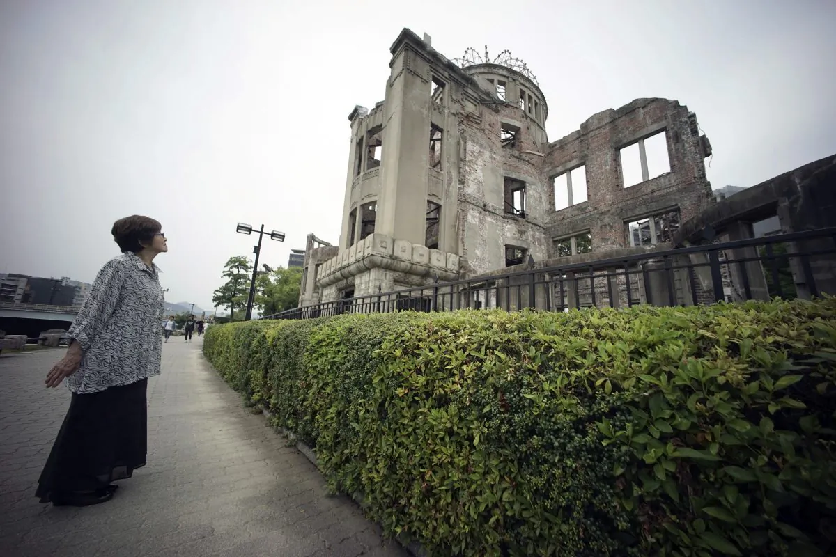 In this July 3, 2015 photo, Kimie Mihara, a survivor of the 1945 atomic bombing, looks at the Atomic Bomb Dome, as it is known today in Hiroshima, Hiroshima Prefecture, southern Japan. Built in 1915, the dome building was a rare example of Western architecture in Hiroshima at the time. Czech architect Jan Letzel designed it to be a city landmark and an exhibition hall for industrial and cultural promotion. Mihara was a worker at a government office in the dome building in 1945. (AP Photo/Eugene Hoshiko)
