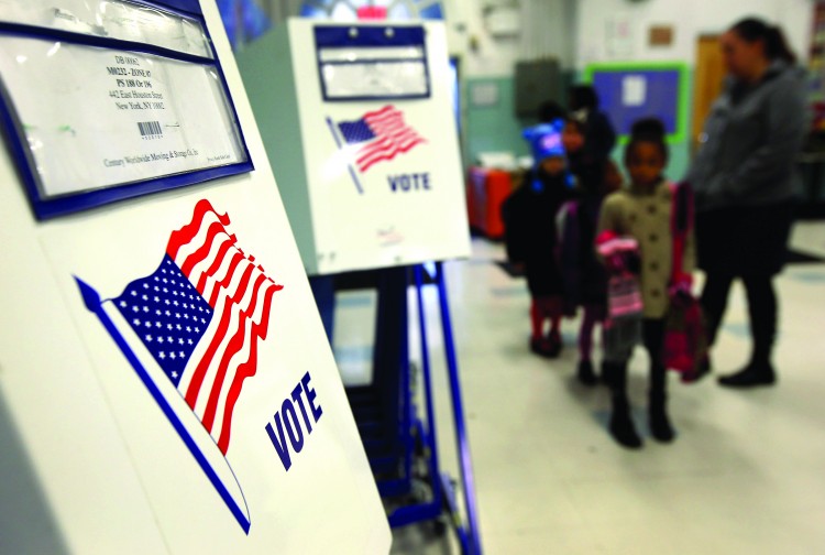 Voting booths stand at the ready as students return to school on Nov. 5 in East Village, Manhattan. Public School 188, will be used as a polling center in Tuesday's presidential election. (John Moore/Getty Images)