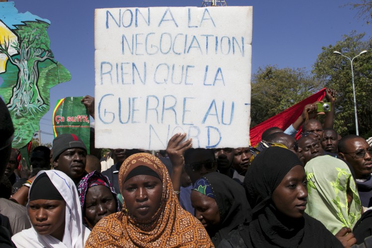 A man holds a banner that reads 'No to negotiation, only war in the north' as thousands of Malians gather in Mali's capital, Bamako, on Dec. 8, 2012. Malians are divided—some call for foreign military intervention to reclaim the north, controlled for eight months by Islamist armed groups, while some fear intervention could bring a new bout of tension and a new humanitarian crisis. (HABIBOU KOUYATE/AFP/Getty Images) 
