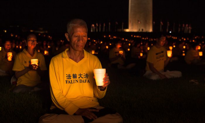 Practitioners of Falun Dafa (also Falun Gong) hold a candle light vigil by the Washington Monument on July 16, 2015, to commemorate the 16 years their fellow practitioners have been facing persecution in China. (Petr Svab/Epoch Times)