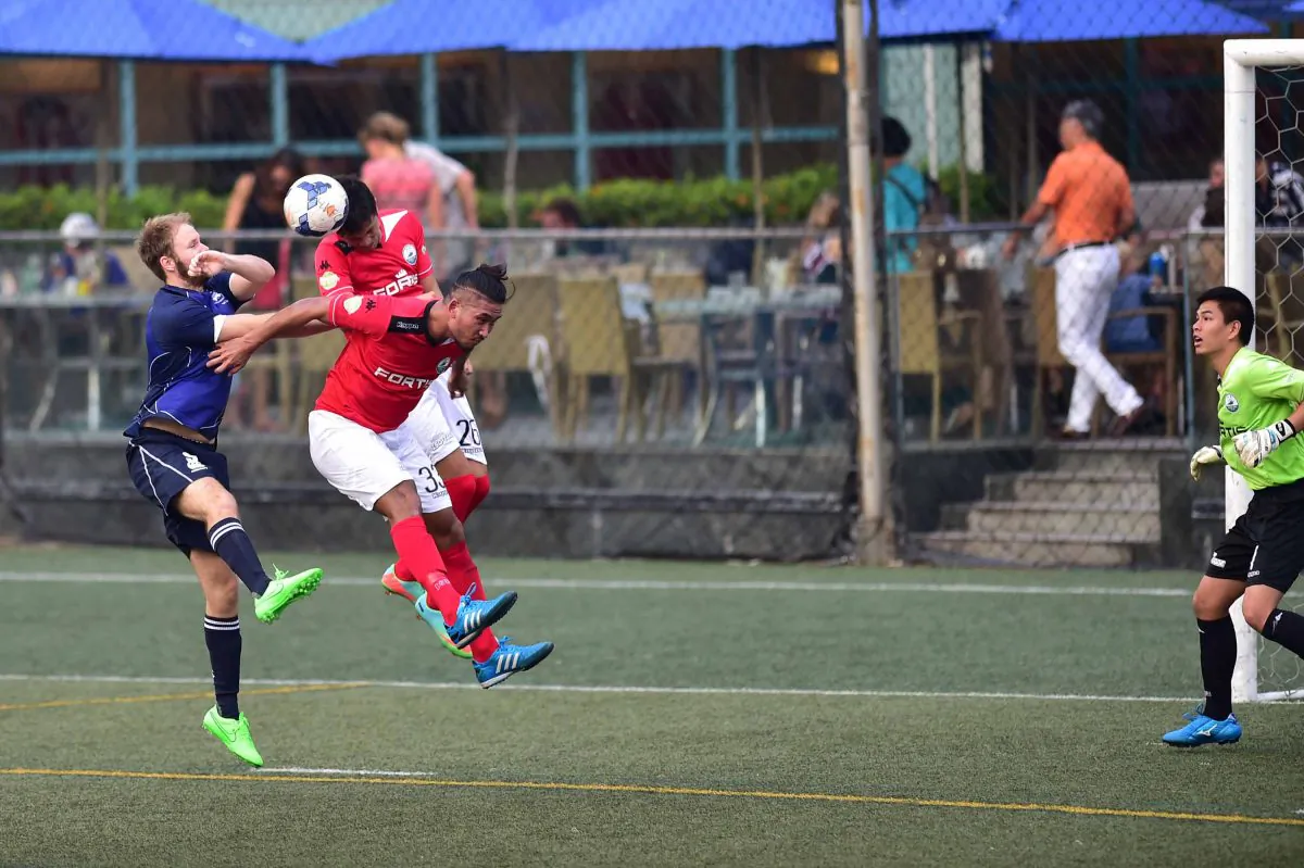 An on target header by Robbie Bacon of HKFC (Blue) gives HKFC their first goal in their 3-1 win over Sun Hei in the HKFA First Division at the HKFC on Sunday Sept 13. (Bill Cox/Epoch Times)