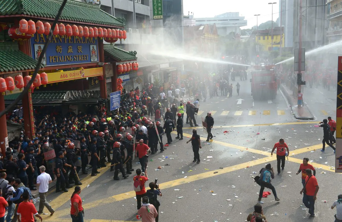 Riot police fire a water cannon to pro-government "red shirt" protesters as they try to enter China Town during a demonstration in Kuala Lumpur, Malaysia, Wednesday, Sept. 16, 2015. (AP Photo)
