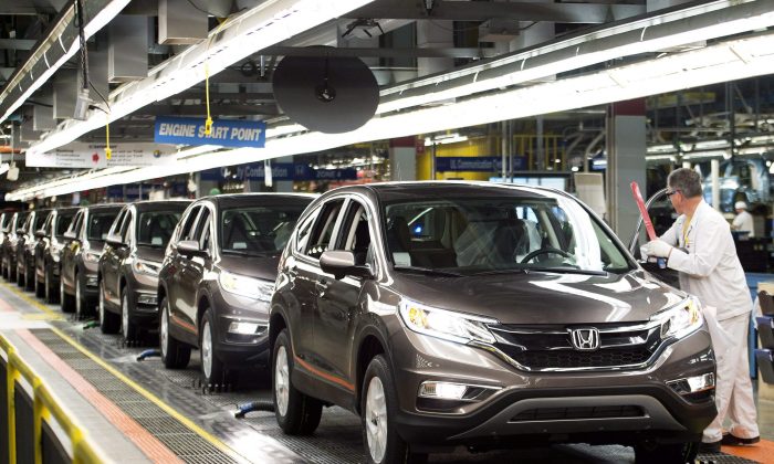 Workers inspect cars on the assembly line at a Honda plant in Alliston, Ontario on March 30, 2015. The transportation sector continues to lead the rise in Canadian manufacturing. (The Canadian Press/Nathan Denette)