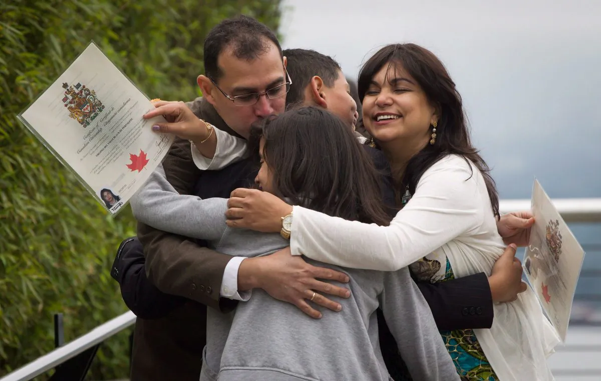 Adrian Pernalete (L) and his family, originally from Venezuela, participate in a group hug after being sworn in as Canadian citizens during a special Canada Day citizenship ceremony in Vancouver on July 1, 2012. (Darryl Dyck/The Canadian Press)