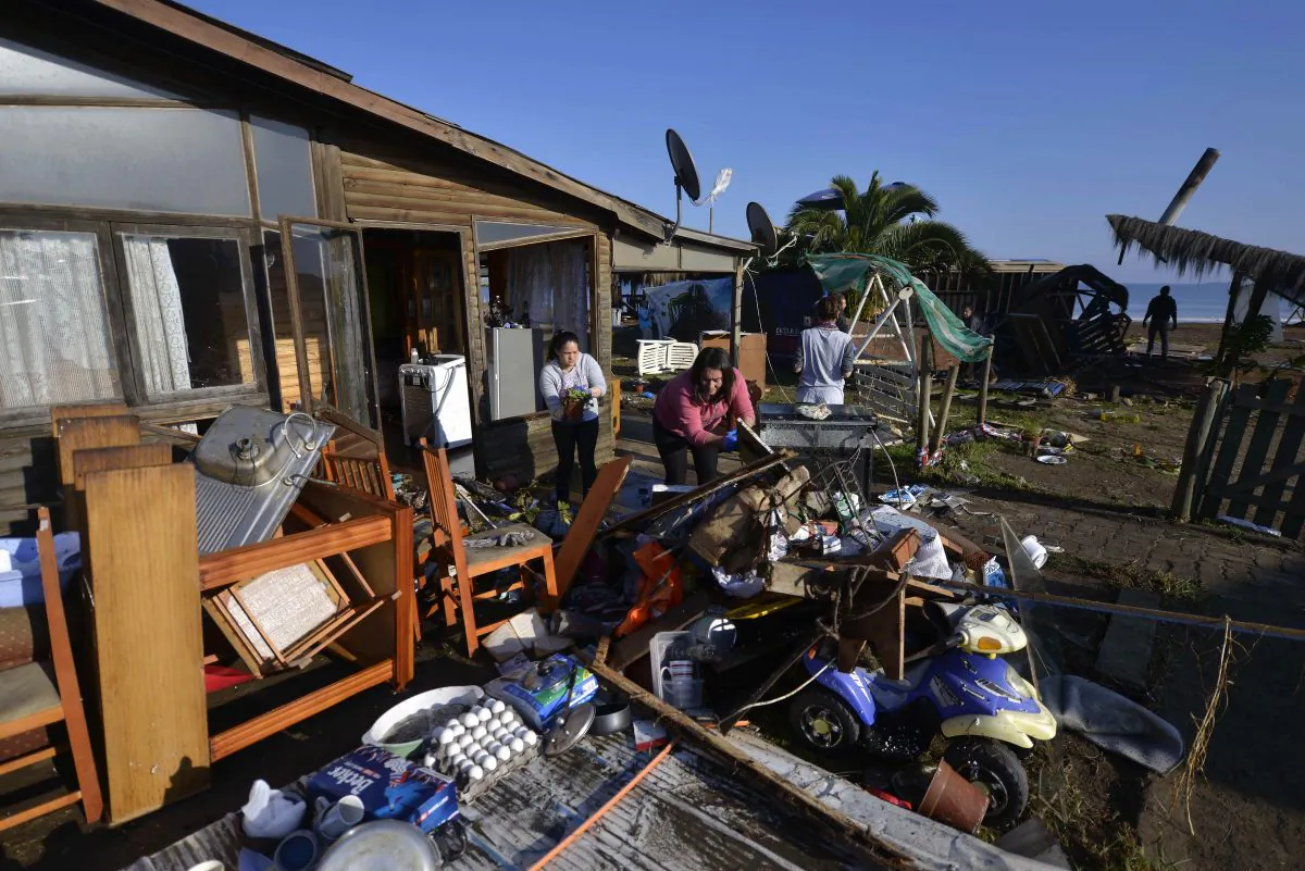 Women dry their belonging outside their home after an earthquake-triggered tsunami flooded their home in Concon, Chile, Thursday, Sept. 17, 2015.  (AP Photo/Matias Delacroix) 