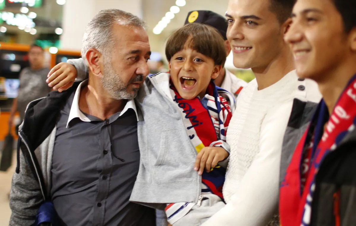 Syrian Osama Abdul Mohsen, left, holds his son Zaid as they arrive at the Barcelona train station on Wednesday, Sept.16, 2015. (AP Photo/Manu Fernandez)
