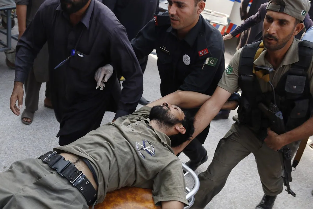 Pakistani security officials rush their colleague to a local hospital in Peshawar, Pakistan, on Sept. 18, 2015, after the Taliban launched a brazen assault on a military base on the outskirts of the northwestern city. (AP Photo/Mohammad Sajjad)
