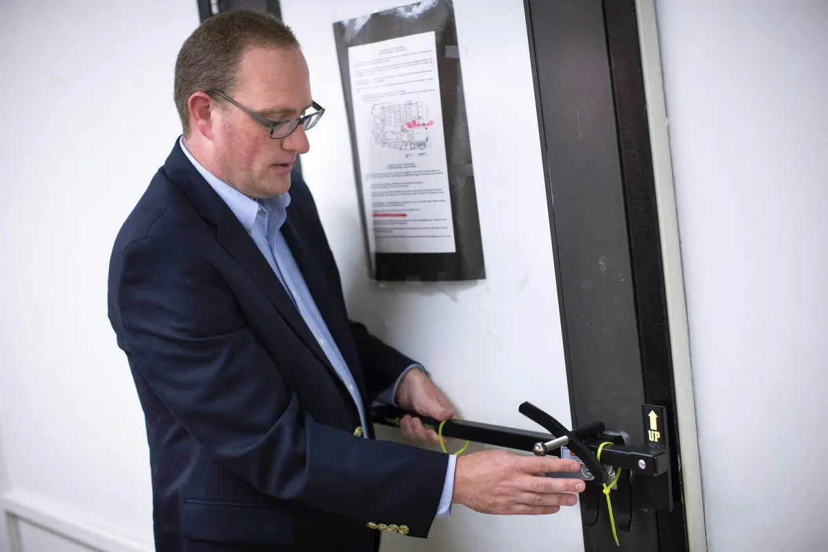 In this Monday, July 20, 2015 file photo, Ben Richards, principal of Watkins Memorial High School, demonstrates the use of an ALICE, or Alert Lockdown Inform Counter Evade, device in Pataskala, Ohio. (AP Photo/John Minchillo)
