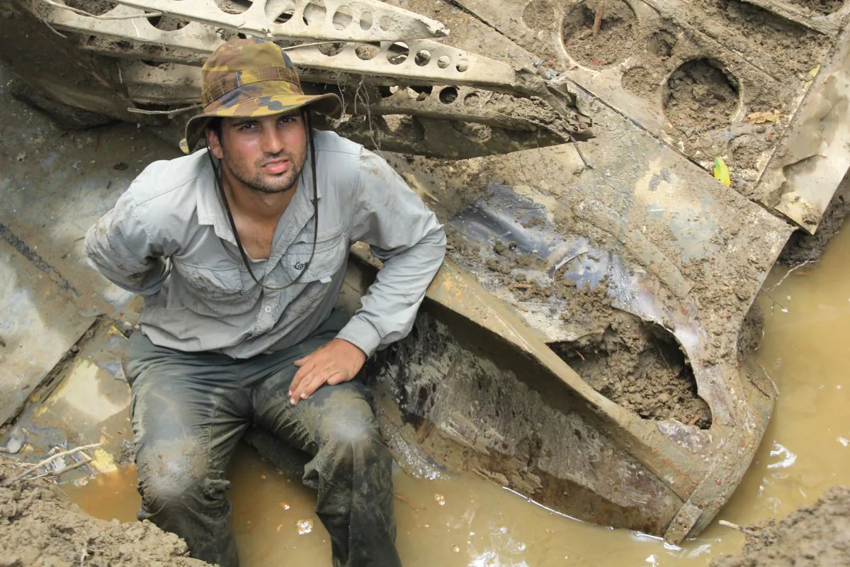 In this 2014 photo provided by Pacific Wrecks, Justin Taylan, founder and director of Pacific Wrecks poses at a World War II airplane wreck site in Papua New Guinea (PNG). (Marcus Browning/Pacific Wrecks via AP)