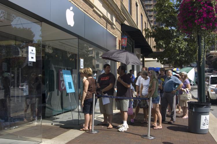 Shoppers line up in front of an Apple store during a previous tax-free event in Kansas City, Mo. Tax-free savings will apply to select clothing items and school supply items that cost less than $100. (The Epoch Times)