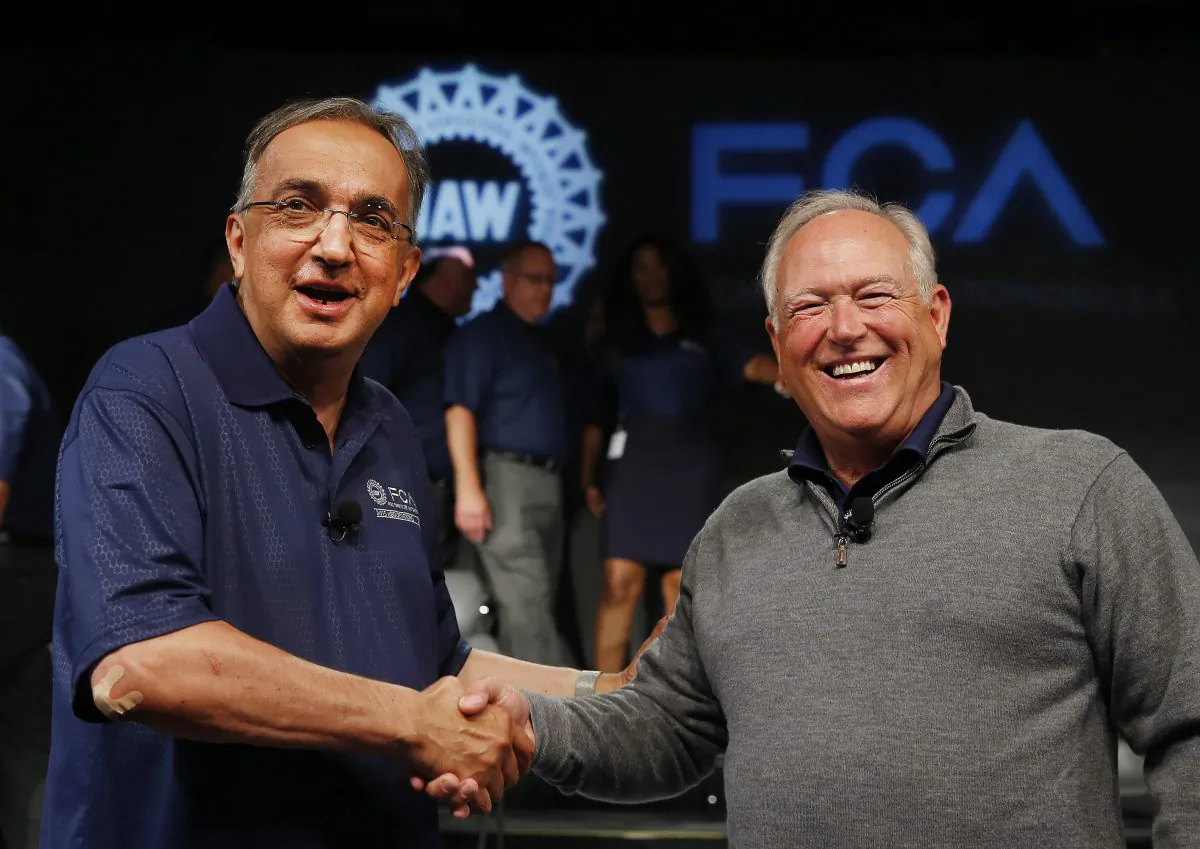 Fiat Chrysler Automobiles CEO Sergio Marchionne (L) and United Auto Workers President Dennis Williams shake hands during a ceremony to mark the opening of contract negotiations in Detroit on July 14, 2015. (AP Photo/Paul Sancya)