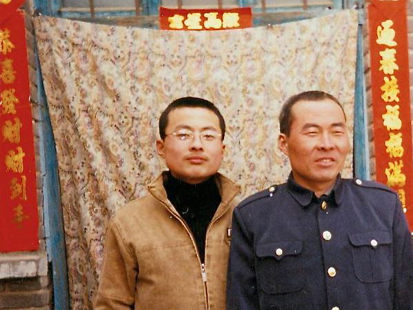 Li Lankui (R) stands with his son before his arrest