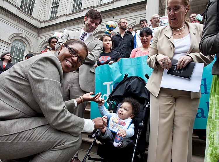 Councilwoman Letitia James plays with a child at a protest calling for New York City Council to pass a law mandating paid sick days Oct. 4. (Amal Chen/The Epoch Times)