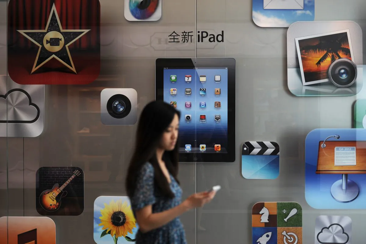 A woman walks by an Apple store in Shanghai on July 20, 2012. (PETER PARKS/AFP/GettyImages)