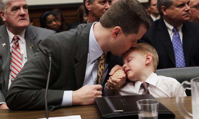 Peter Hurley comforts his son Jacob Hurley during a House Energy and Commerce Committee hearing on Capitol Hill in Washington, DC, Feb. 11, 2009. (Mark Wilson/Getty Images)
