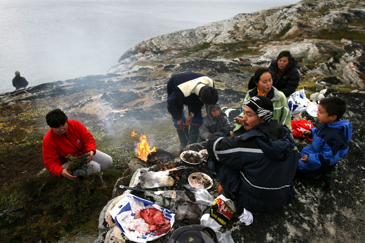 Arne Lange, a 39-year-old Inuit fisherman and his family have a family seal meat barbecue. (Photo by Uriel Sinai/Getty Images)