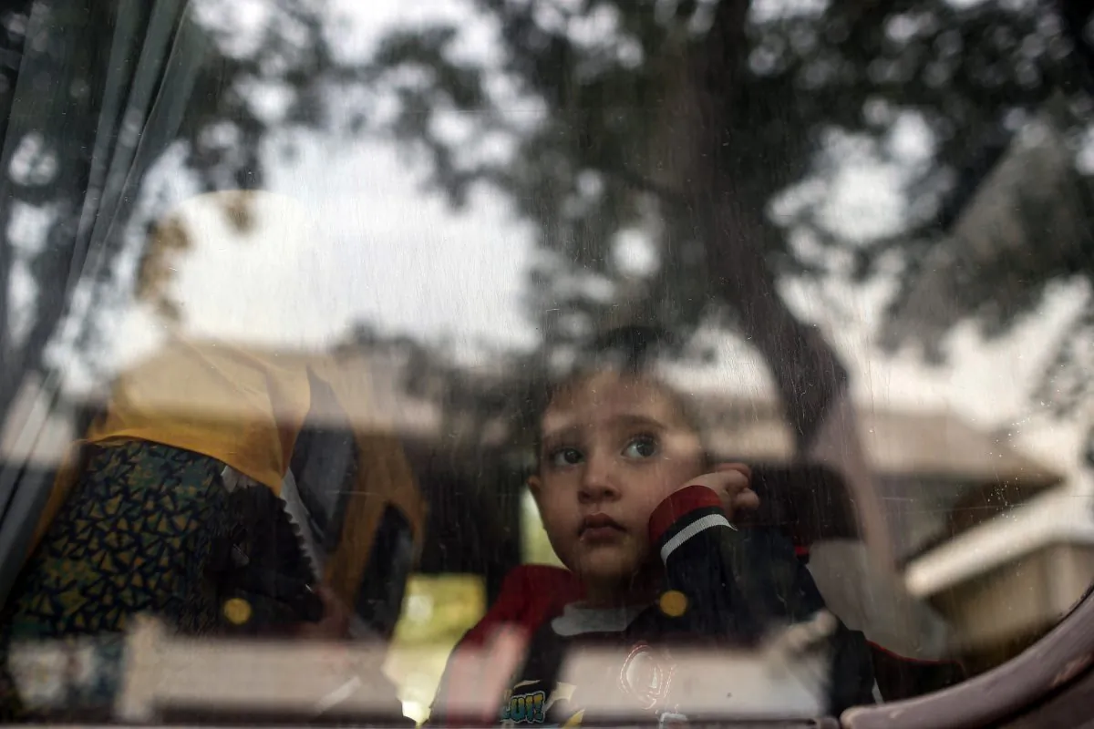 A refugee child looks through a bus window as they leave for Istanbul, abandoning plans to cross to Europe near Turkey’s western border with Greece and Bulgaria, in Edirne, Turkey, Wednesday, Sept. 23, 2015. (AP Photo/Emrah Gurel)