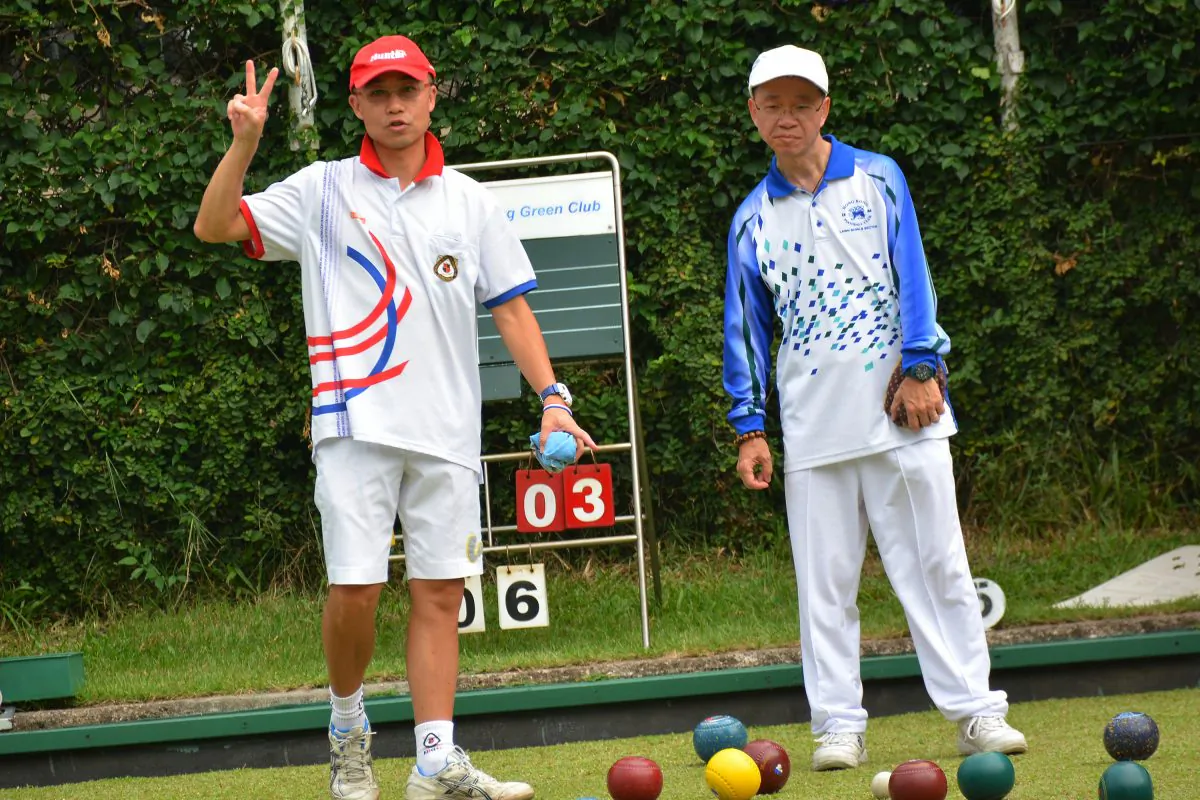 VICTORY!! Hong Kong international Stanley Lai (left) showed his Kowloon Bowling Green Club teammate the number of shots they are holding during his league match against Wagner Chan of Hong Kong Football Club on Sept 19, 2015. Lai emerged victorious by a big margin of 25:6. (Mike Worth)