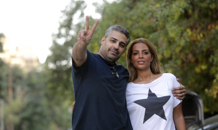 A triumphant Mohamed Fahmy poses with his wife Marwa Omara after being released from prison in Cairo, Egypt, on Sept. 23, 2015. Fahmy and his colleague Baher Mohammed were among a group of 100 people pardoned by Egyptian President Abdel-Fattah el-Sissi. (AP Photo/Amr Nabil)