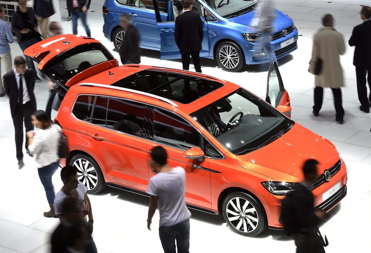 Visitors look at a Volkswagen Touran at the Frankfurt Auto Show in Frankfurt, Germany, on Sept. 15, 2015. A class-action suit has been launched in Canada after Volkswagen owned up to an organised deception that helped its diesel models slip past emissions testing in Canada and the United States. (AP Photo/Jens Meyer)