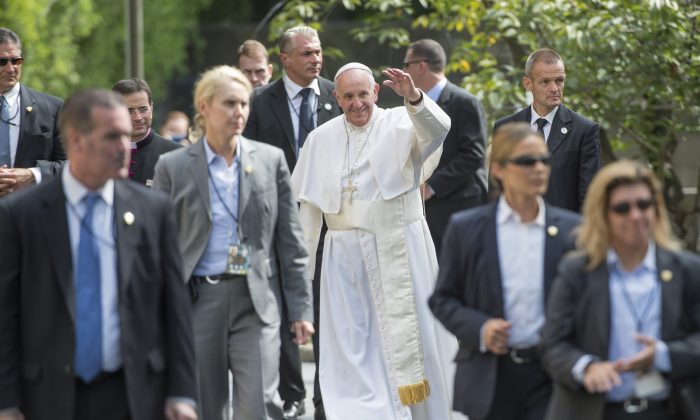 Pope Francis, surrounded by security, waves to well-wishers at the Apostolic Nunciature to the United States upon returning from his trip to Capitol Hill, on September 24, 2015 in Washington, DC.       (MOLLY RILEY/AFP/Getty Images)