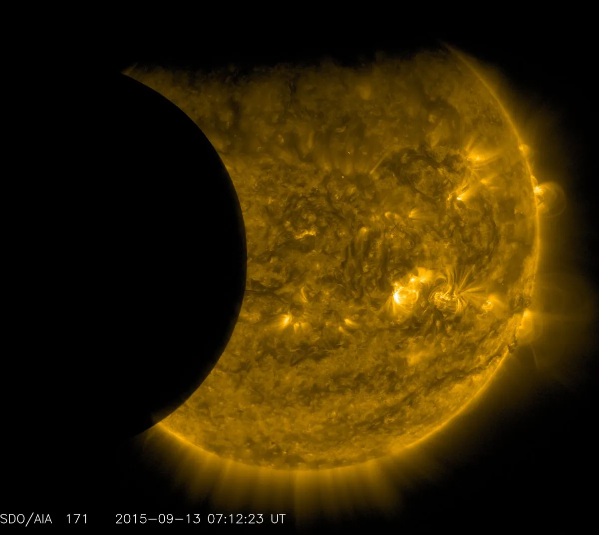 This Sept. 13, 2015 image provided by NASA shows the moon, left, and the Earth, top, transiting the sun together, seen from the Solar Dynamics Observatory.  (NASA/SDO via AP)