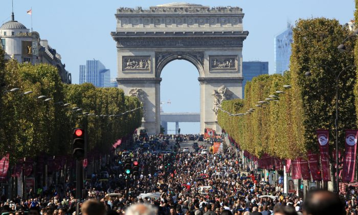 People walk on the Champs Elysees during the "day without cars", in Paris, France, Sunday, Sept. 27, 2015. Pretty but noisy Paris, its gracious Old World buildings blackened by exhaust fumes, is going car-less for a day. Paris Mayor Anne Hidalgo presided over Sunday's "day without cars," two months before the city hosts the global summit on climate change. (AP Photo/Thibault Camus)