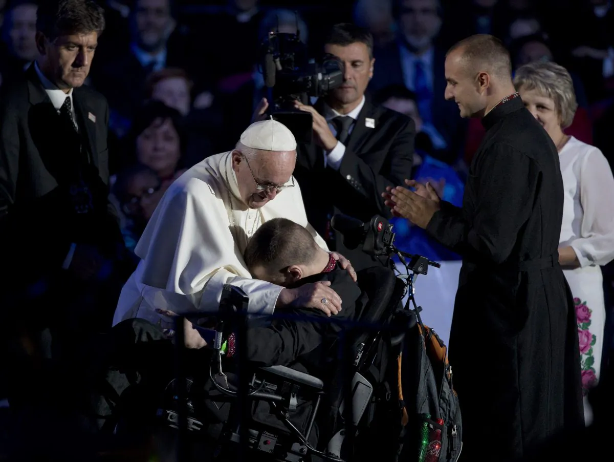 Pope Francis embraces a young man in a wheelchair during the World Meeting of Families in the Benjamin Franklin Parkway Saturday, Sept. 26, 2015, in Philadelphia. Hundreds of thousands of Roman Catholics made the pilgrimage to Philadelphia to see Pope Francis on the last leg of his visit to the United States, where they hoped to catch a glimpse of the popular pontiff at some point during his packed schedule — or even receive a blessing or healing touch. (AP Photo/Alessandra Tarantino)