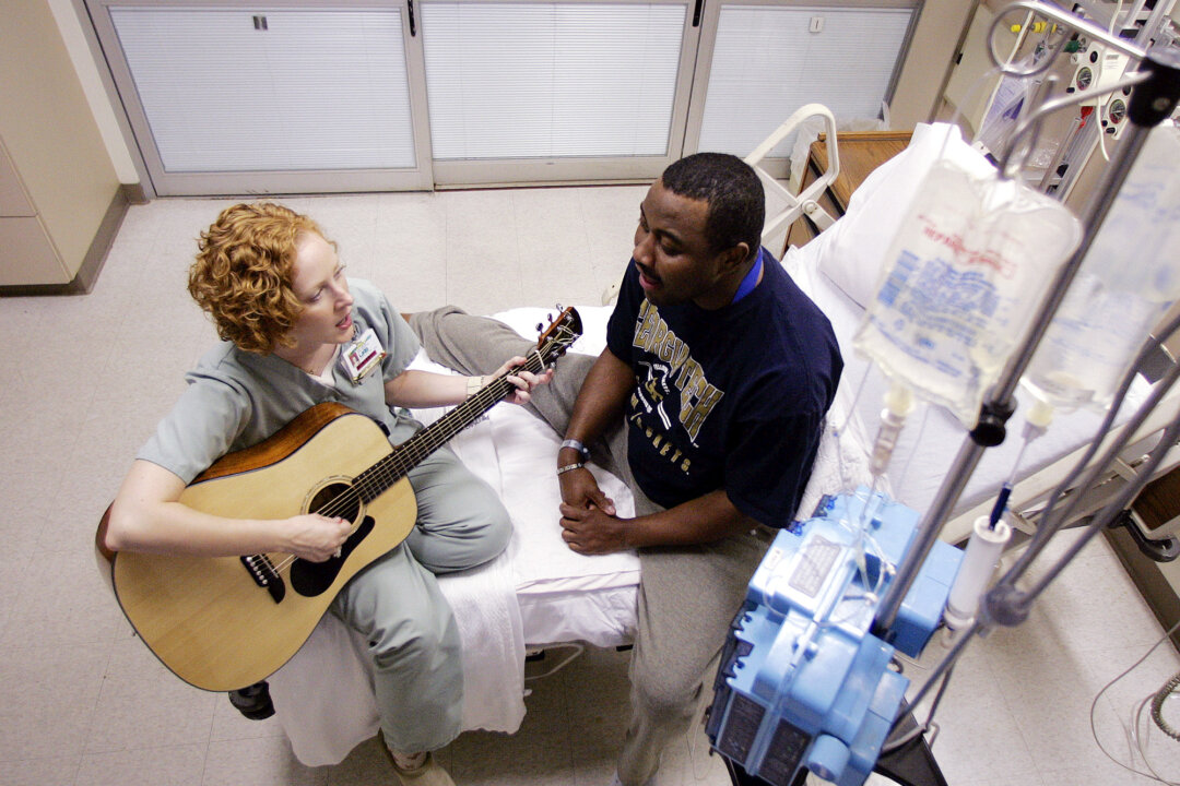  A hospital music therapist  plays her guitar and sings along with a patient at a hospital in Atlanta in this file photo. Music therapy can be deeply emotionally healing. (AP Photo/Dave Martin)

