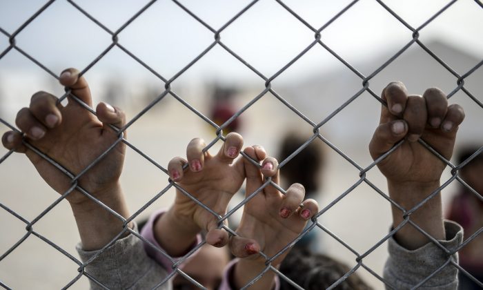 Hands of Syrian Kurdish children holding a fence in a UNHCR refugee camp at Suruc, in Sanliurfa, Turkey, on Feb. 2, 2015. (Bulent Kilic/AFP/Getty Images)