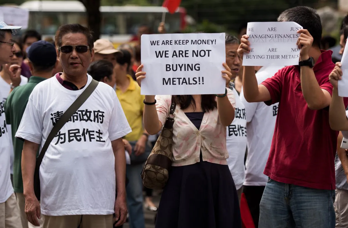 Protesters against the Fanya metals exchange hold placards outside the office of the China Insurance Regulatory Commission in Shanghai on Sept. 25. (Johannes Eisele/AFP/Getty Images)