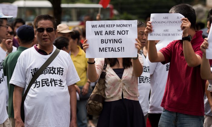 Protesters against the Fanya metals exchange hold placards outside the office of the China Insurance Regulatory Commission in Shanghai on Sept. 25. (Johannes Eisele/AFP/Getty Images)