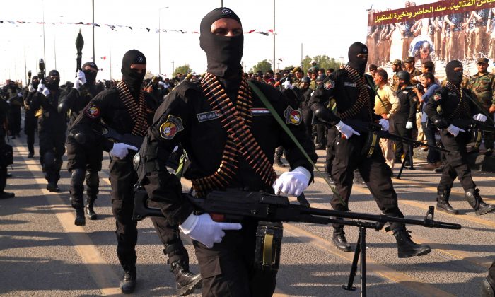 Armed members of the Abbas combat squad, a Shiite militia group, march in a military parade in Basra, 340 miles (550 kilometers) southeast of Baghdad, Iraq, Saturday, Sept. 26, 2015.  (AP Photo/Nabil al-Jurani)