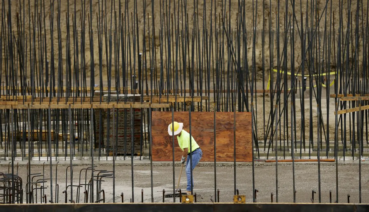 A worker sweeps gravel on the construction site of the new water treatment plant in Ames, Iowa, on Sept. 17, 2015. (Charlie Neibergall/AP Photo)