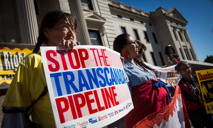 PIERRE, SD - OCTOBER 13:  People participate in a protest against the proposed Keystone XL pipeline on October 13, 2014 in Pierre, South Dakota. Numerous Native American tribes, ranchers, politicians and people against the pipeline came together to hold a rally on the steps of the state's capital building.  (Photo by Andrew Burton/Getty Images)