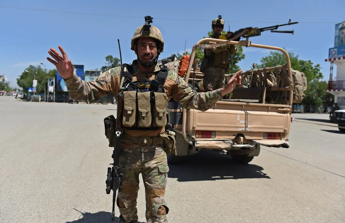 An Afghan security force personel stops journalists from taking photographs in Kunduz on April 30, 2015. (SHAH MARAI/AFP/Getty Images)